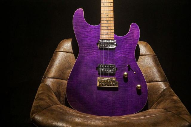 Contrôler le manche d'une guitare électrique d'occasion Guitare électrique posée sur un établi de luthier, manche et frettes visibles